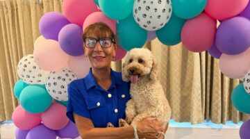 Birthday balloons with paw prints, woman and her dog celebrating