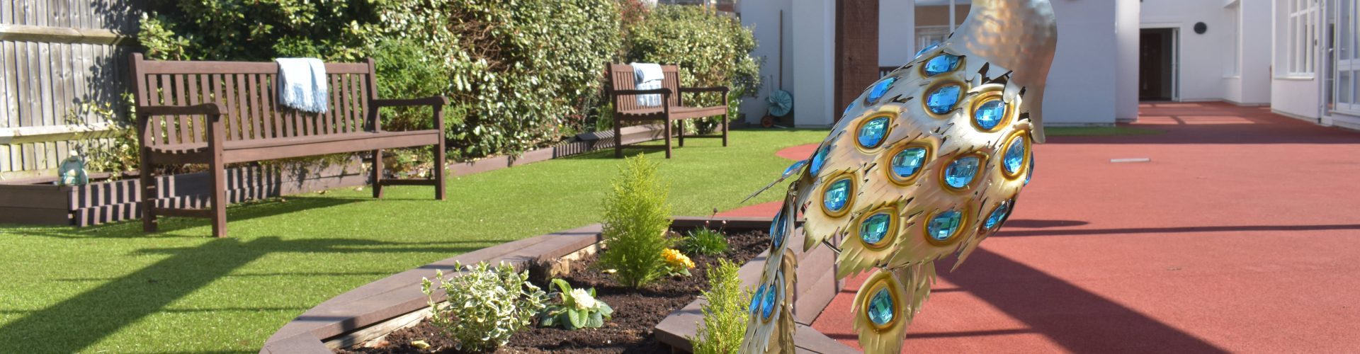 Lynwood Care Centre Garden with Decorative Peacock Sculpture, a care home in Ascot.