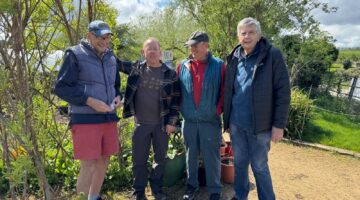 Group of gardeners smiling outdoors in spring sunshine