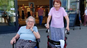 Seniors in wheelchairs outside Stevenage shop entrance