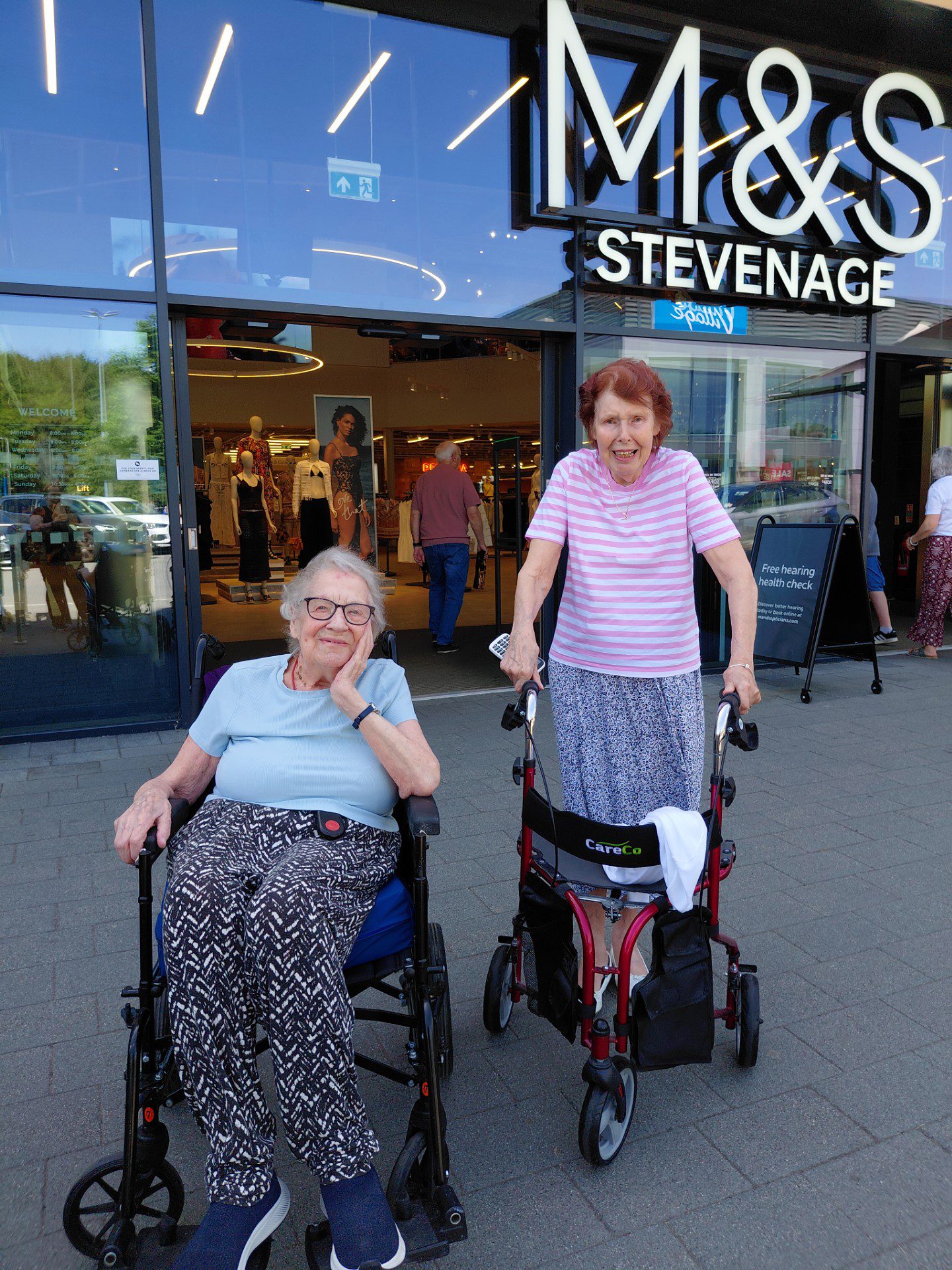 Seniors in wheelchairs outside Stevenage shop entrance