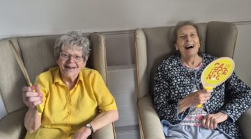 Residents playing tennis with Wimbledon themed rackets at Kingston Care Home