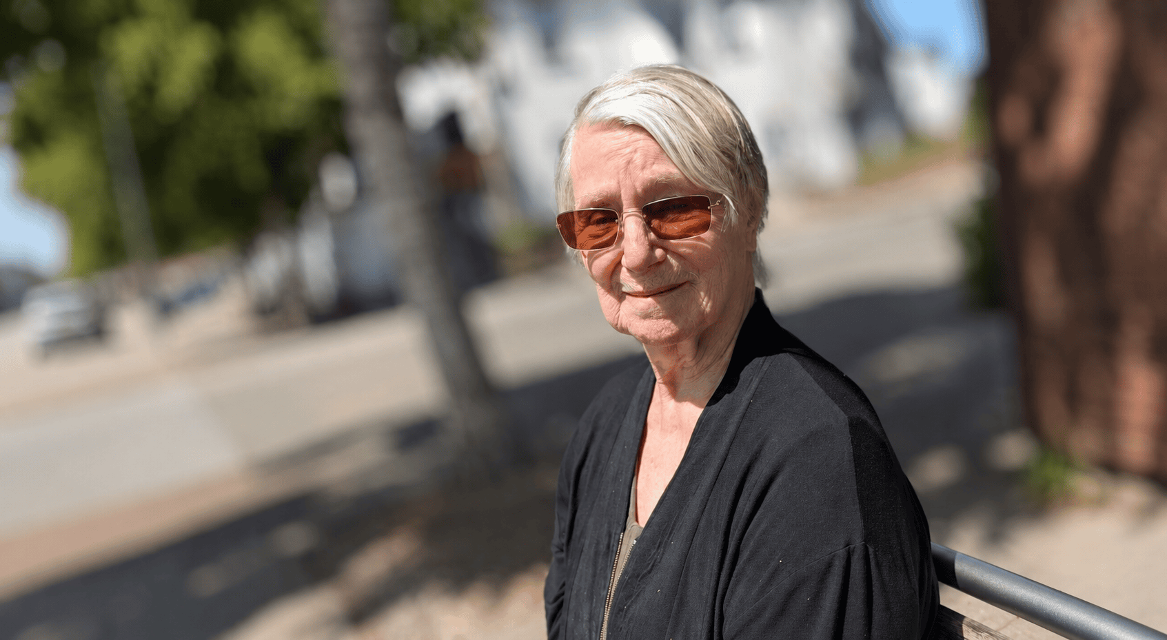 Elderly woman in sunglasses enjoying a sunny stroll in Headington