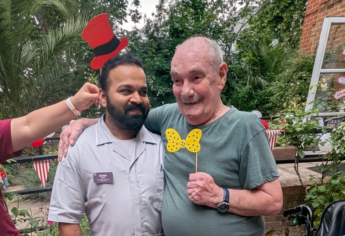 Smiling carers and resident at outdoor garden celebration