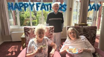Elderly residents enjoy birthday treats with Happy Birthday balloons