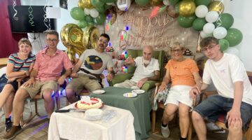 Happy birthday celebration with balloons and family at party table