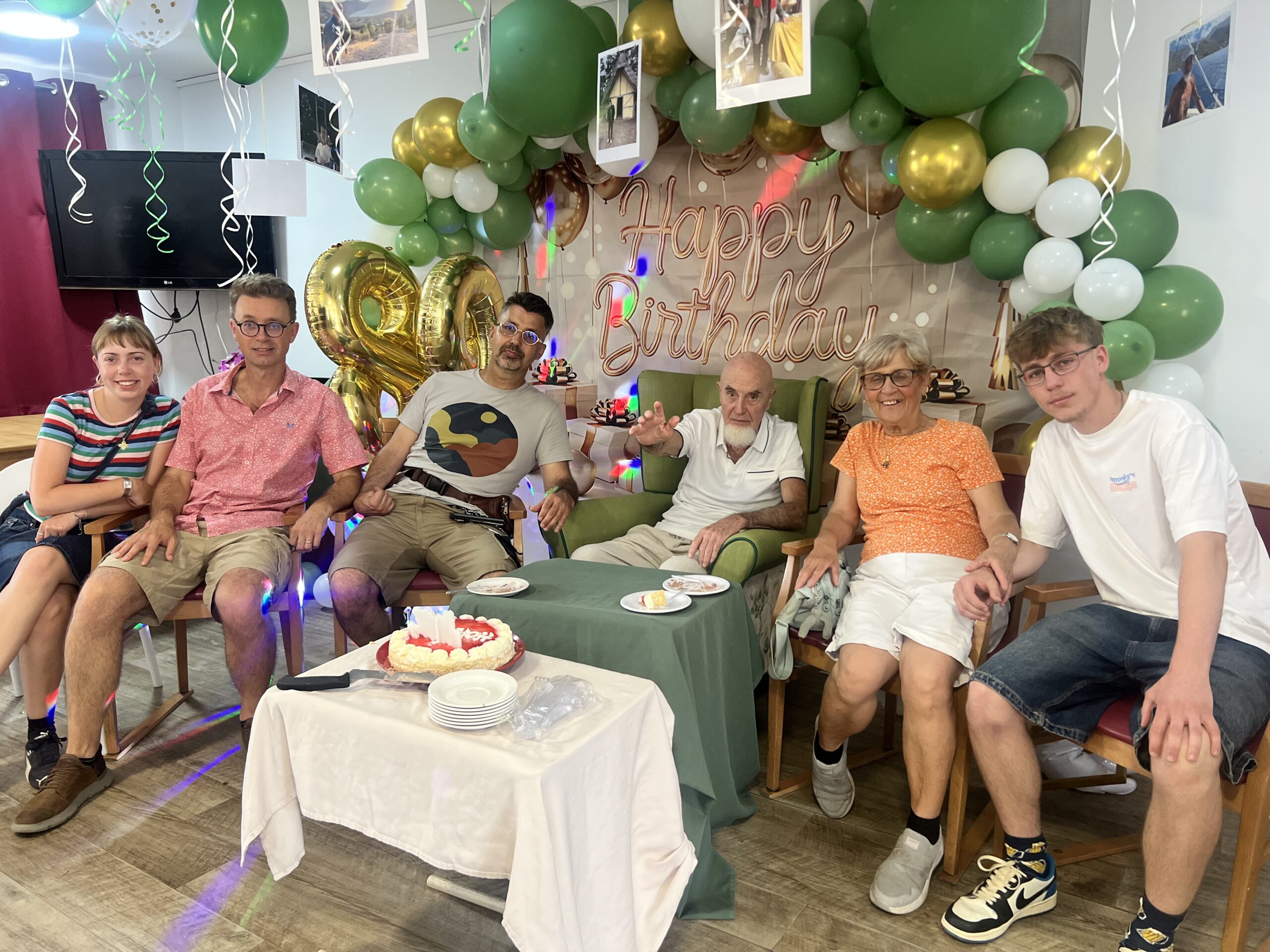 Happy birthday celebration with balloons and family at party table