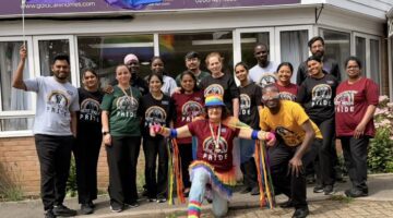 Pride Month care home residents pose together with rainbow flags