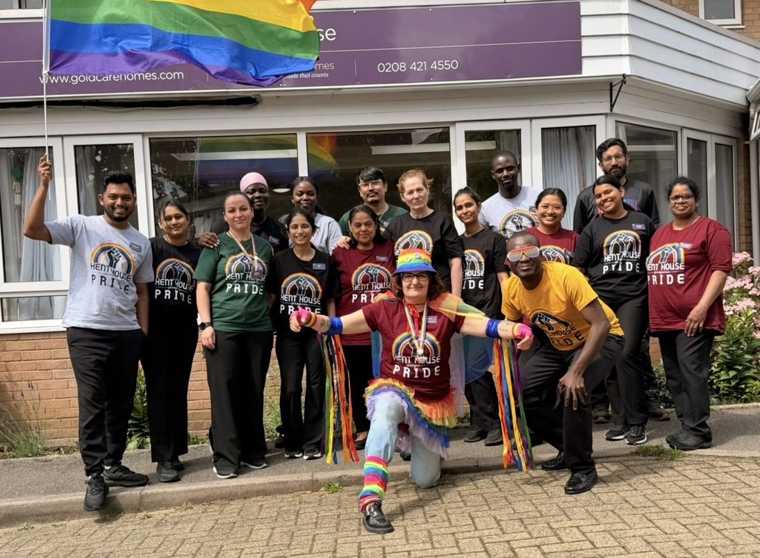 Pride Month care home residents pose together with rainbow flags