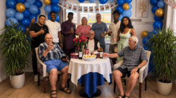 Group birthday party with blue and gold balloons and drinks table