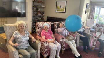 Elderly residents enjoying a care home activity with balloon