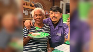 Care worker helps celebrate £114.50 for Macmillan with resident