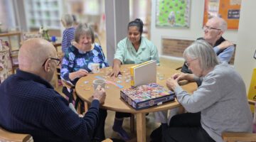 Residents and staff working together on a jigsaw at Lucton House
